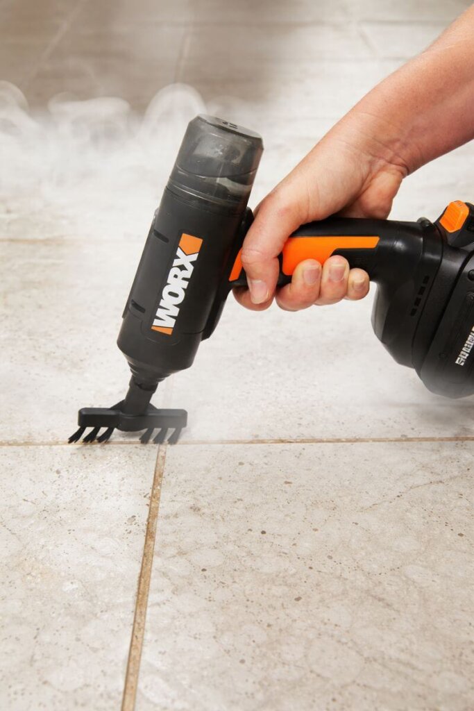 Worx 20V SteamStorm handheld steam cleaner deep cleaning tile grout with a brush attachment and pressurized steam